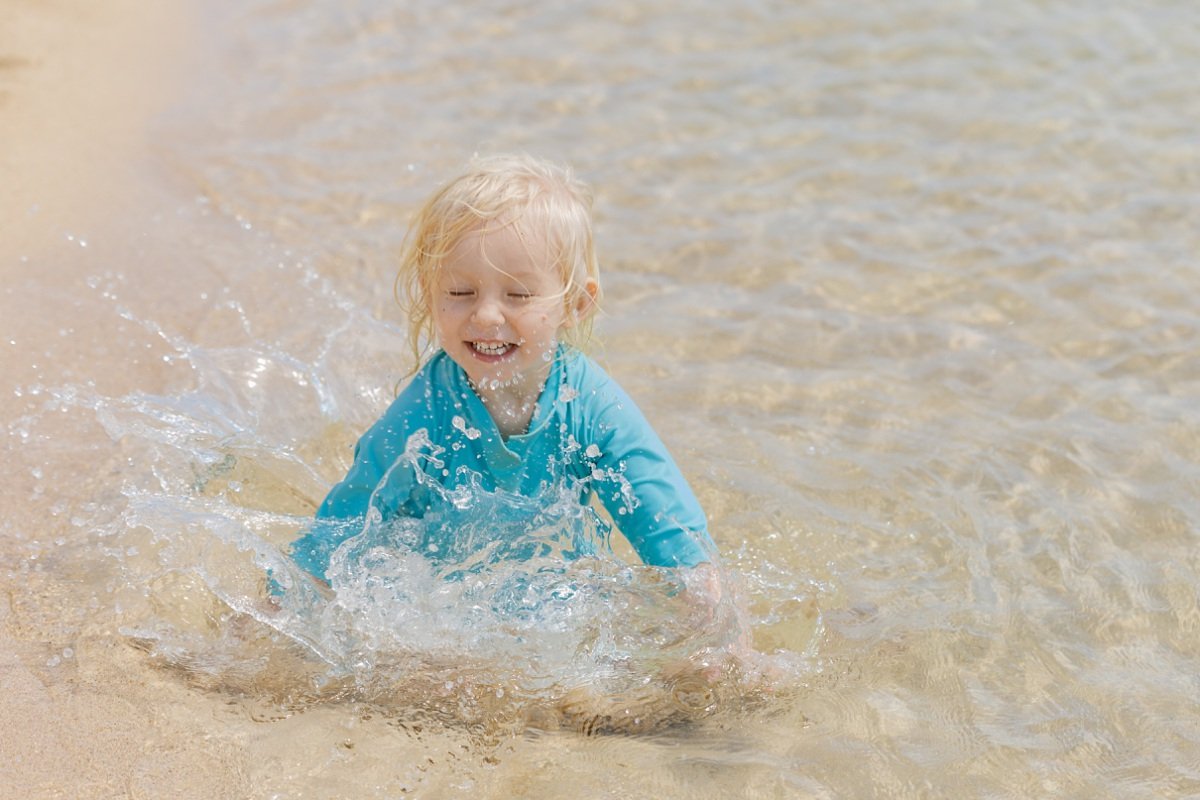toddler splashing in the water iin hawaii
