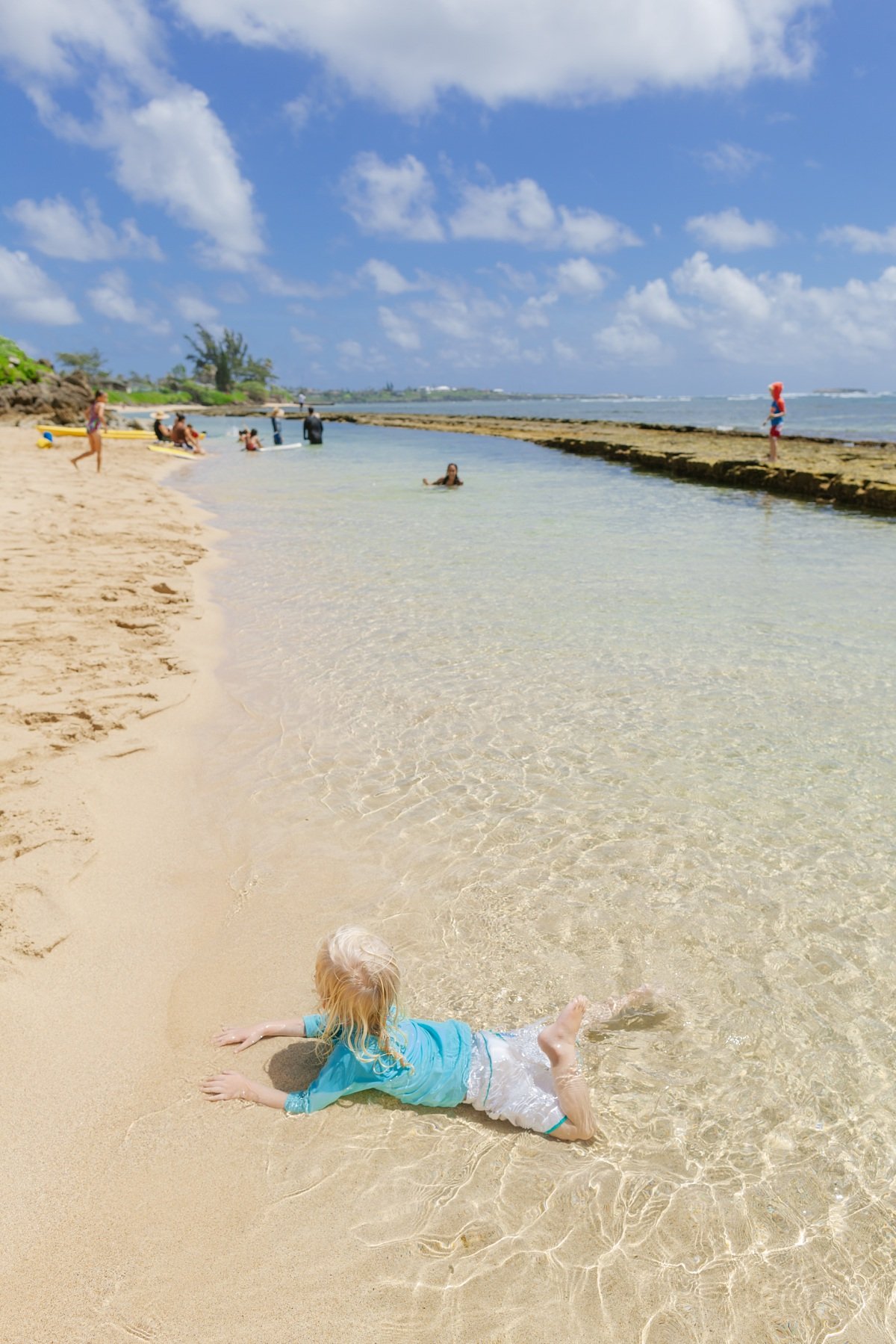 toddler splashing in the shallows at bathtub beach oahu