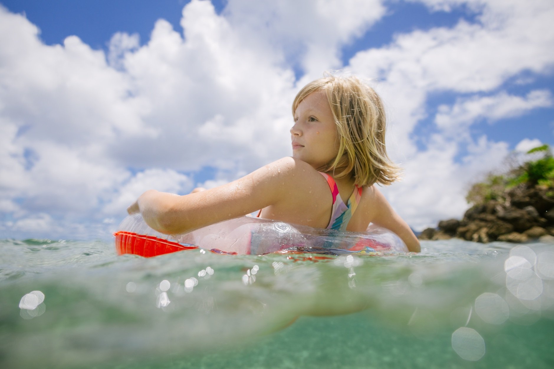 girl floating in clear water at bathtub beach oahu