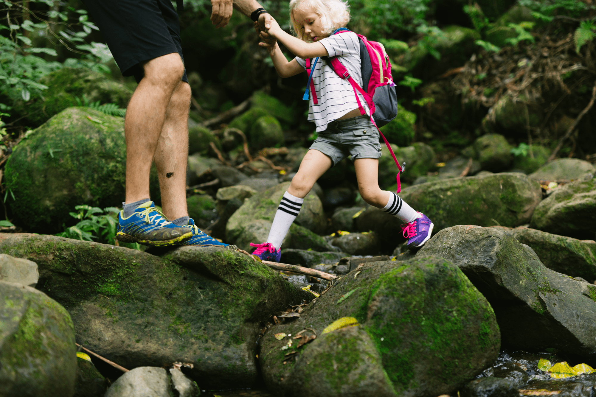 dad helping young daughter on the maunawili trail in oahu
