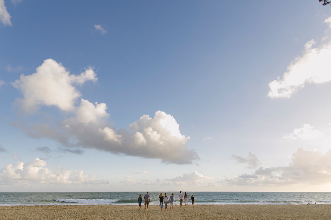 wide shot of a family walking toward the ocean in hawaii