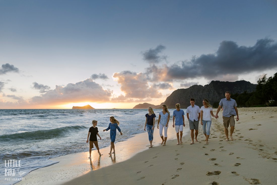 large family walking along the beach at sunrise in hawaii