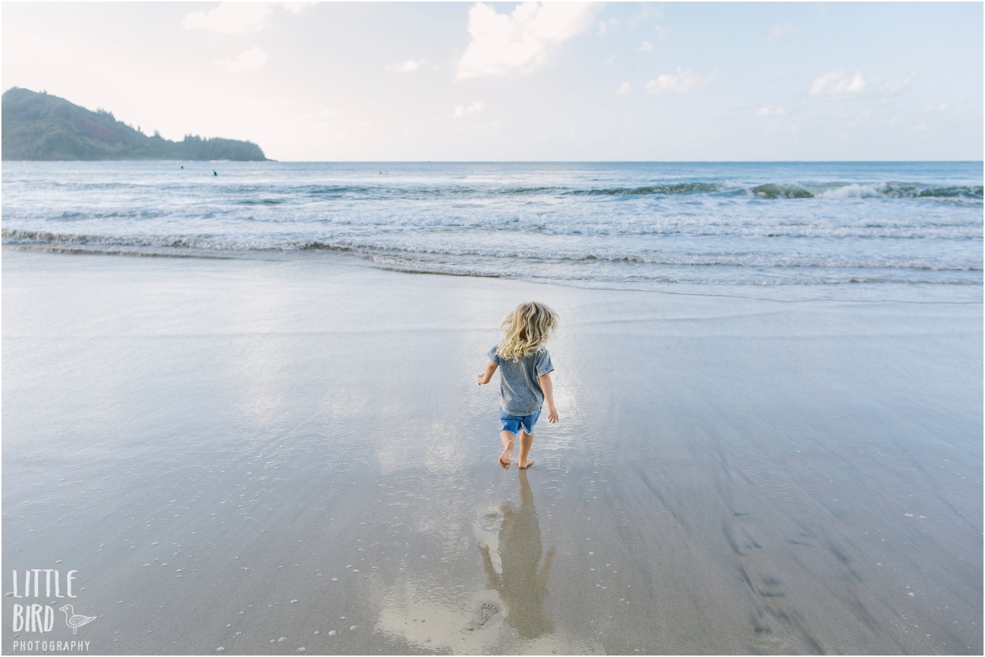 Boy running towards the ocean at Hanalei Bay photo by Little Bird Photography