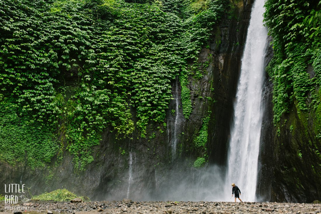 boy at massive waterfall on bali