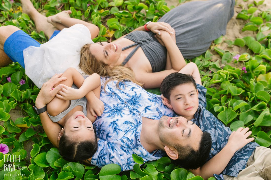 family lies together on beach flowers in oahu for Family Beach Pictures