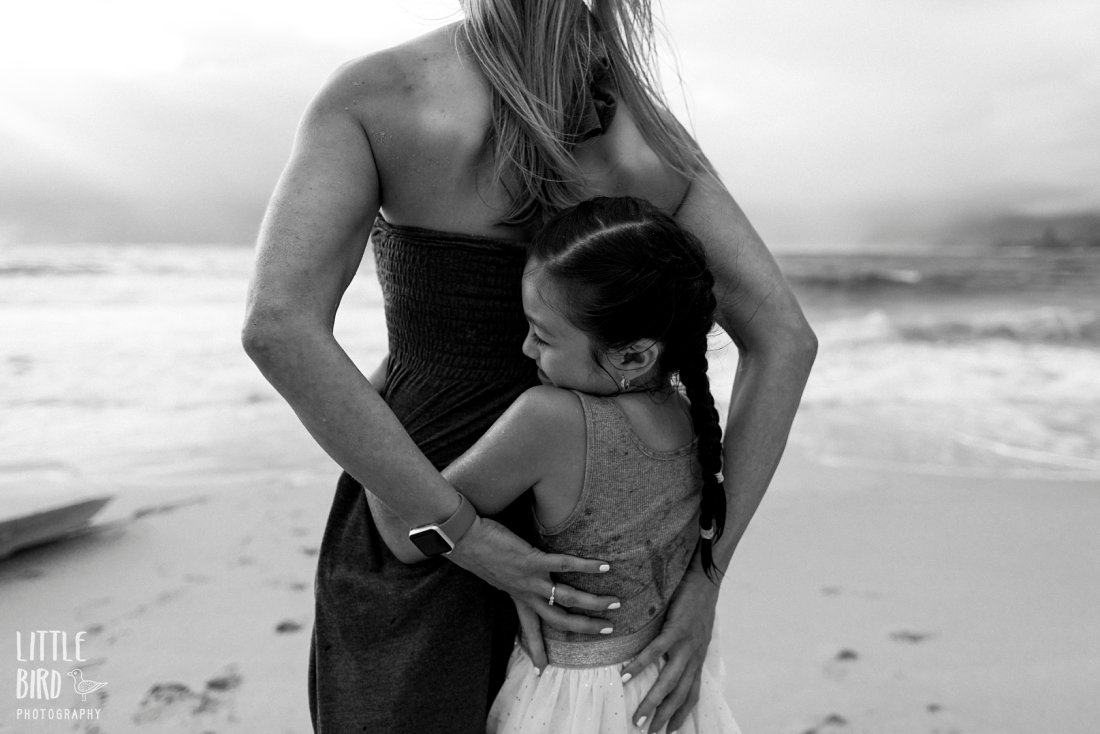 Family Beach Pictures with mom and daughter hugging in black and white by Little Bird Photography