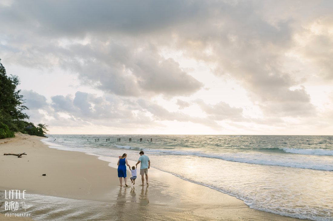 family walking on the beach at sunrise in hawaii