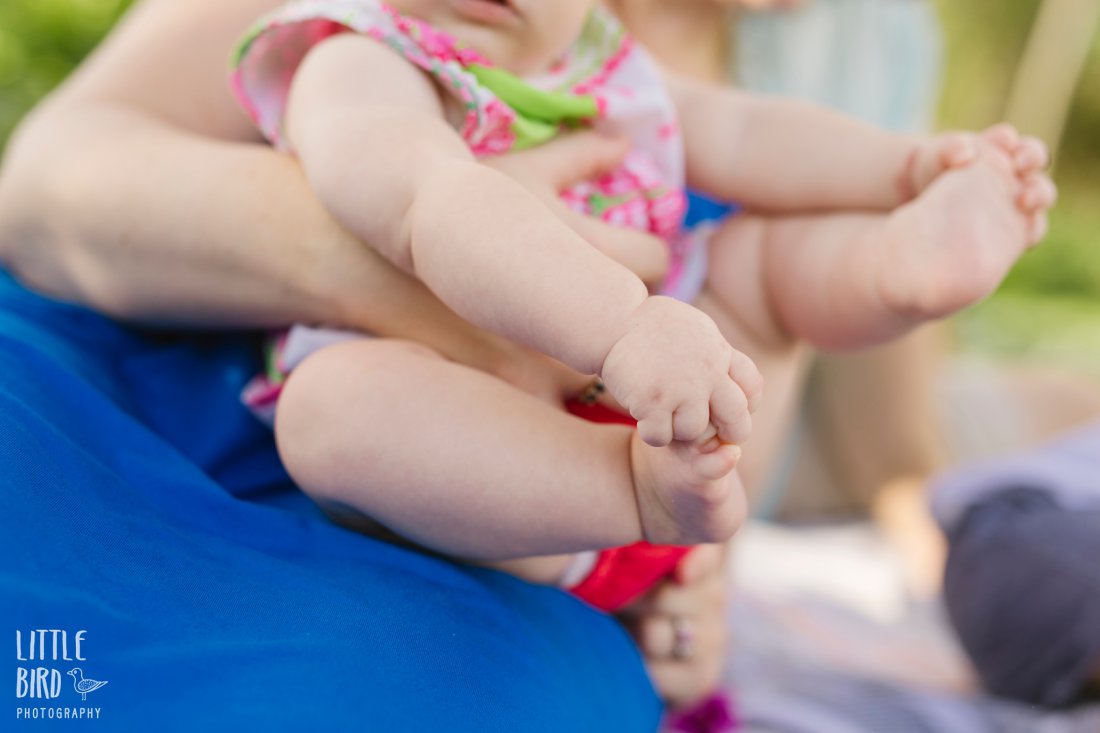 baby holding her toes during family photo shoot