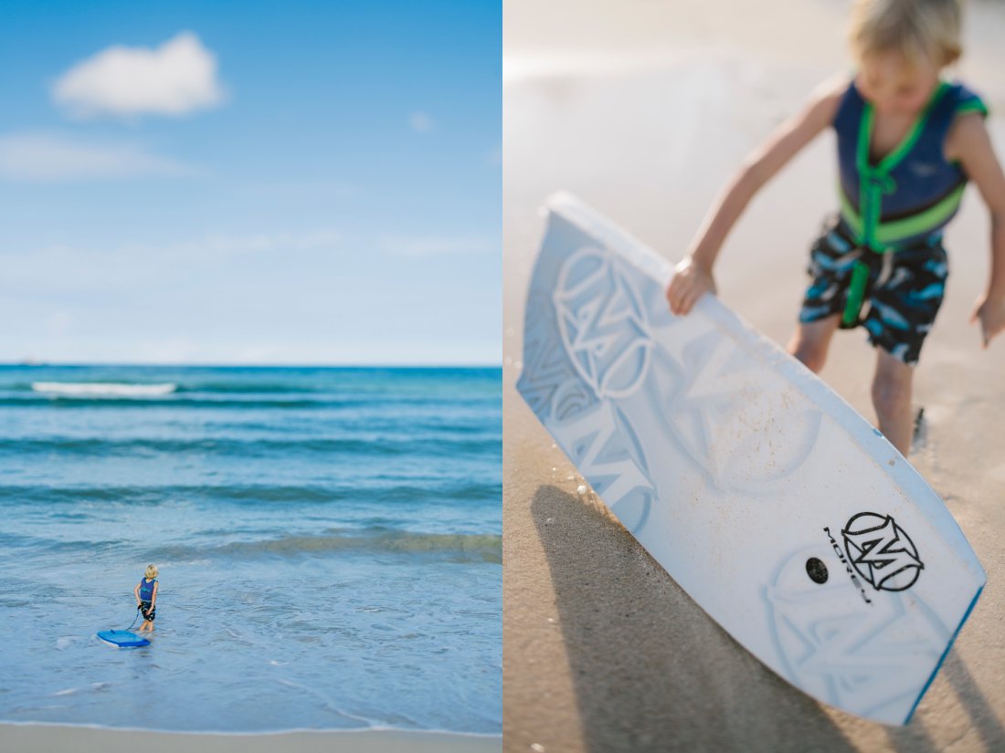boy surveying the waves in hawaii with a body board 