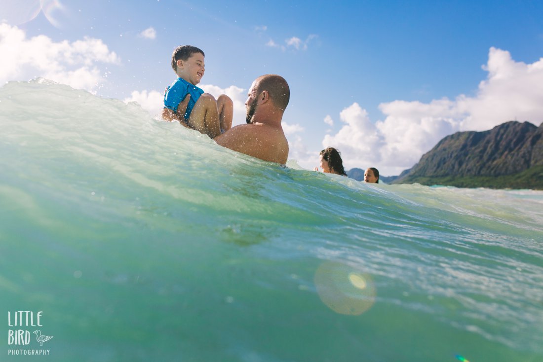 family playing in big waves in waimanalo oahu