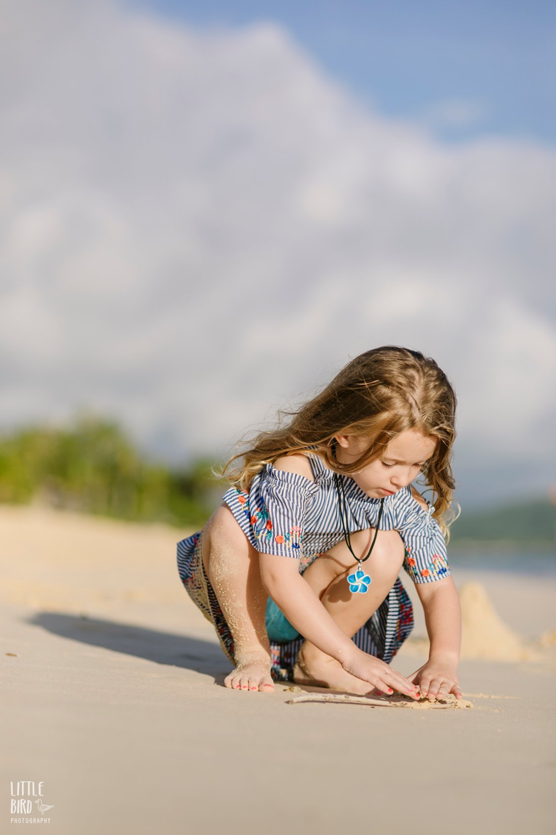 girl playing in the sand at lanikai beach hawaii