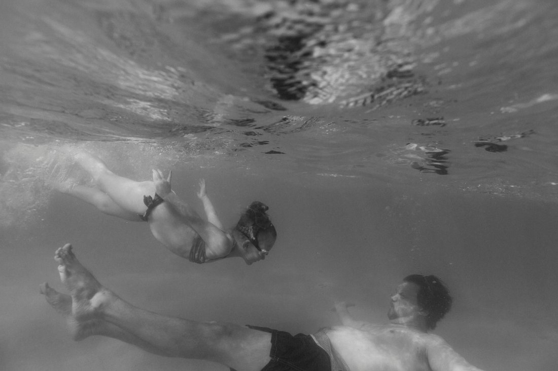 dad and daughter swimming under water in hawaii