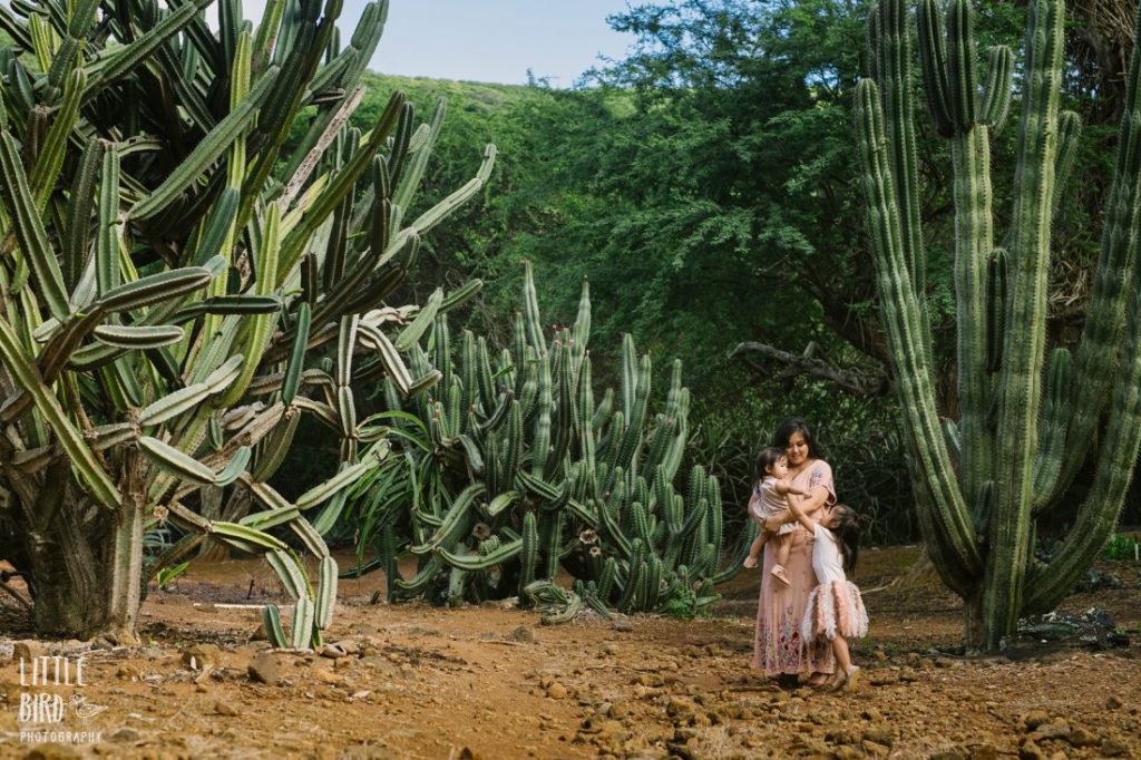mom and daughters stand in a cactus garden in hawaii