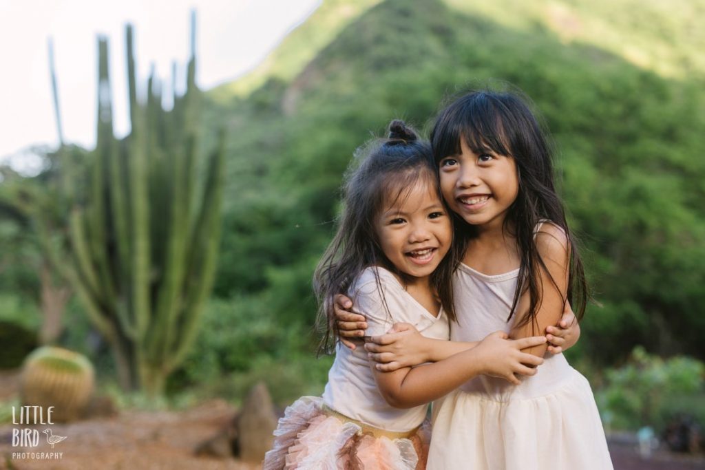 sisters hug during a family photo session in oahu