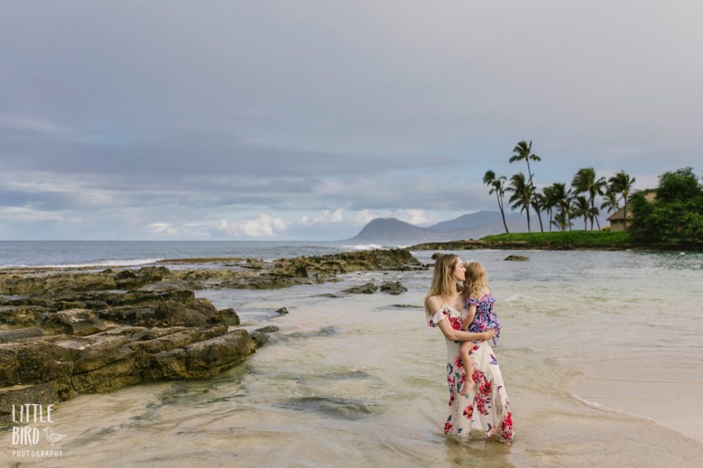 quiet moment between mom and daughter at a hawaii beach