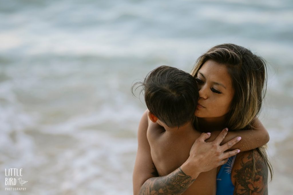 mom comforting son during a family photo session in oahu