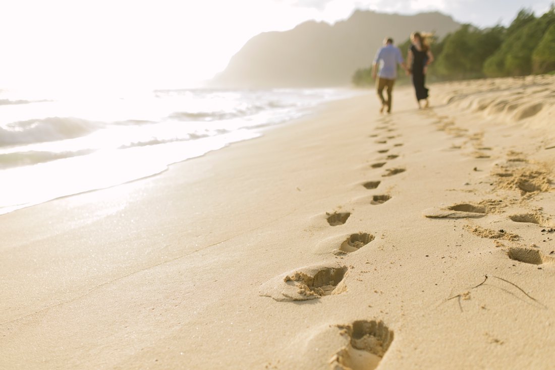 family leaving footprints along waimanalo beach