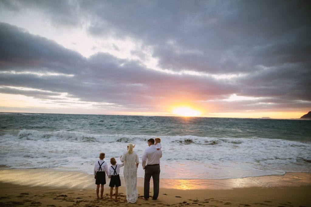 family taking in sunrise during a hawaii vow renewal cermony