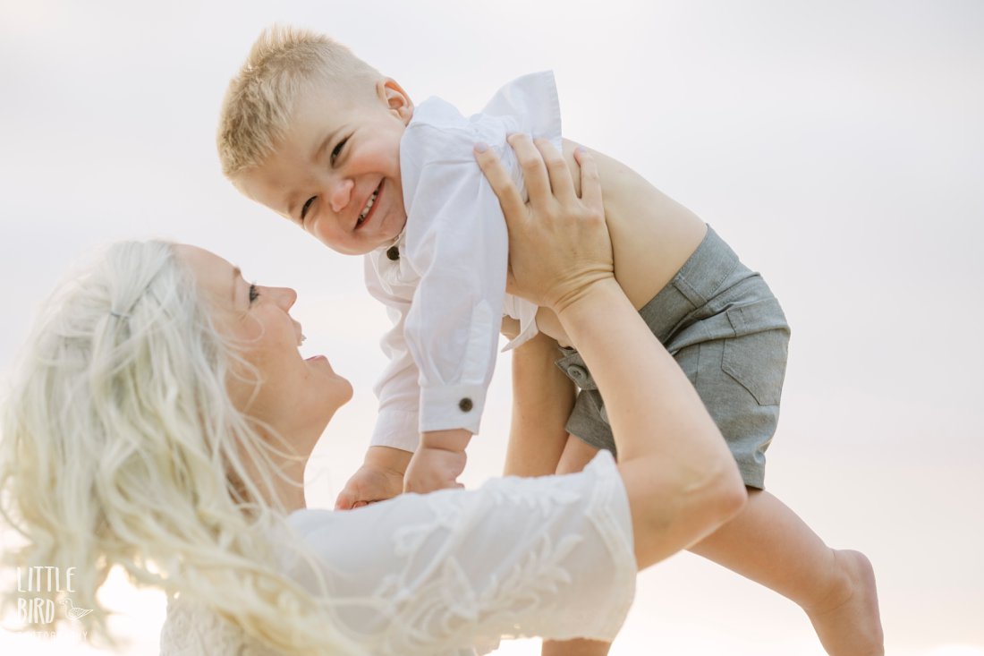 mom holding son in the air during a family photo session