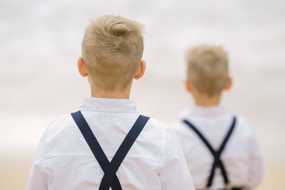 brothers in suspenders at the beach