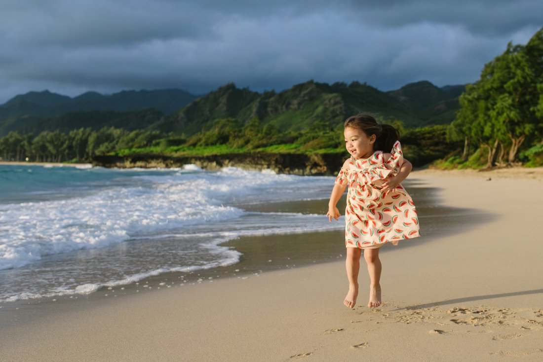 toddler girl jumping at sunrise on the beach in oahu