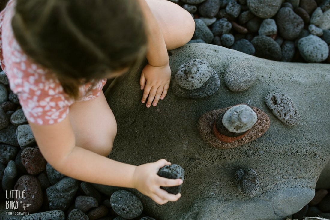 girl stacking rocks in pololu valley