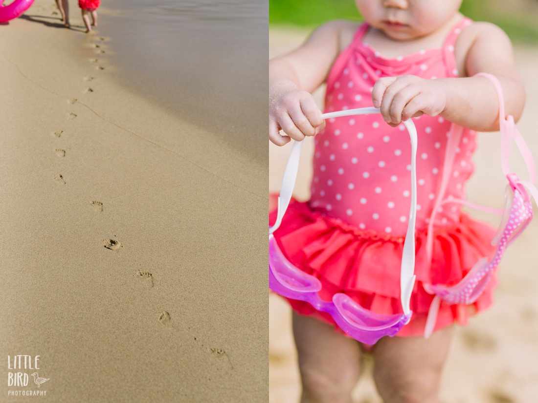 toddler in pink swimsuit playing at the beach during a lifestyle family photo session
