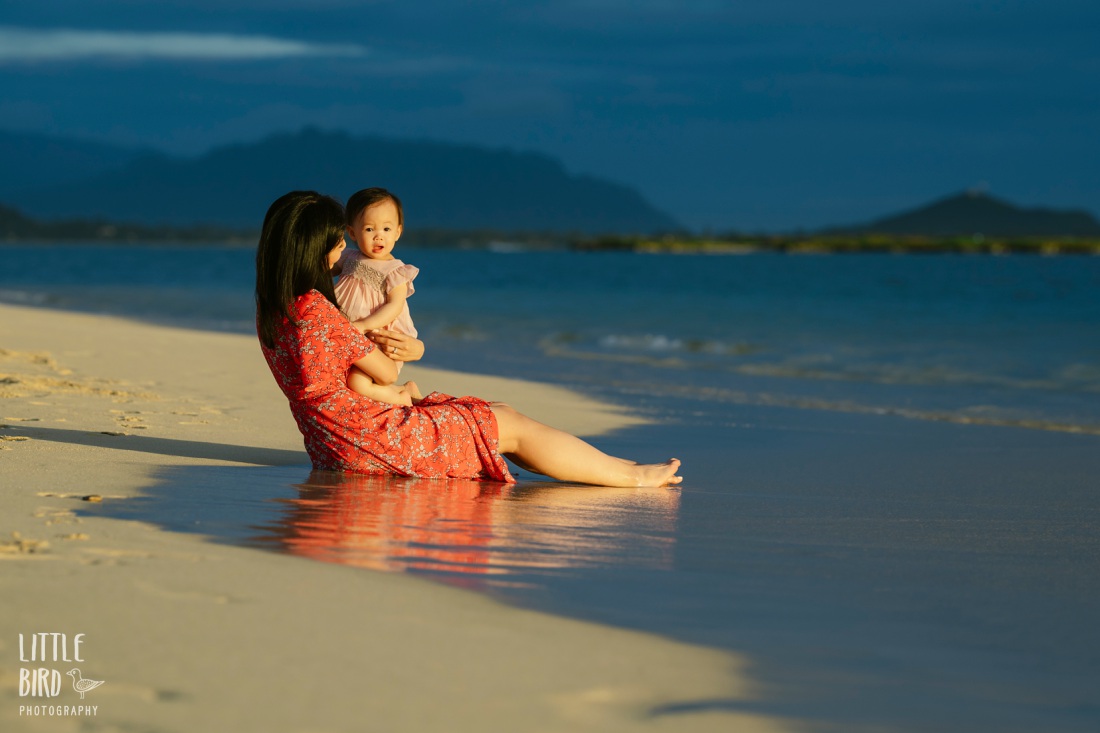 mom and daughter take in sunrise at lanikai beach during a family photo session