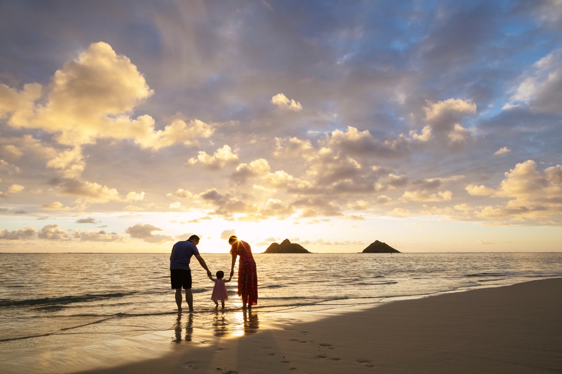 family watching the sunrise over lanikai beach in hawaii