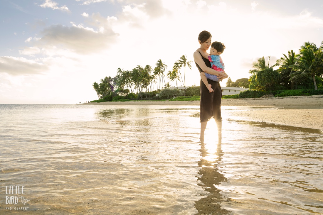 boy and mom snuggling during a beach photo session at Kahala Beach in Waikiki