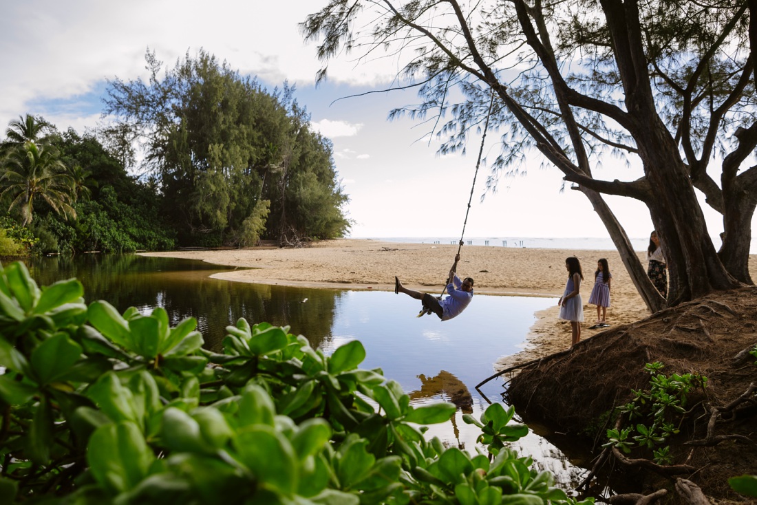 dad playing on the rope swing during a family photo session in oahu