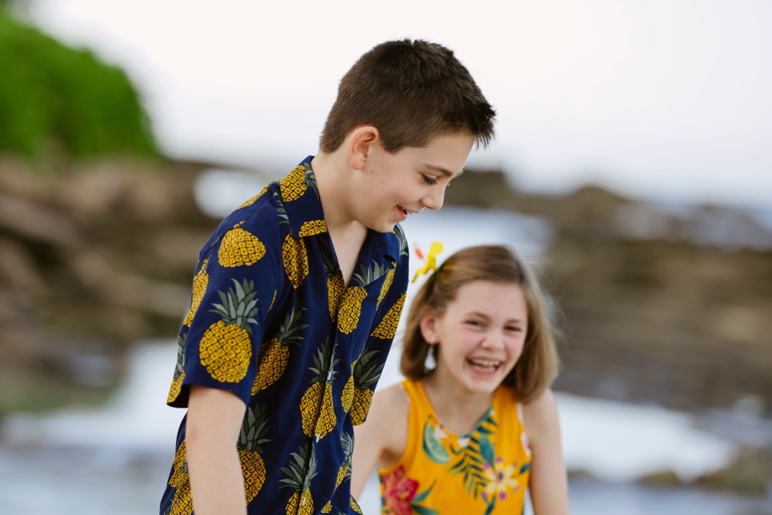 siblings sharing a laugh at the beach in oahu