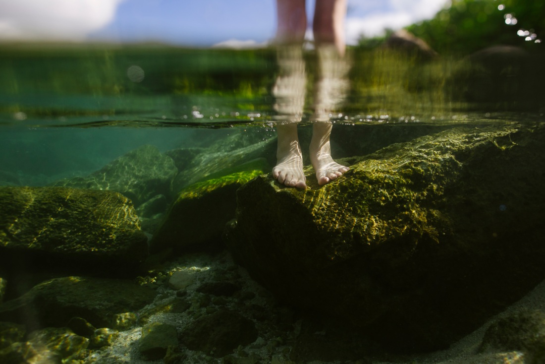 underwater portrait of a girl standing on rocks