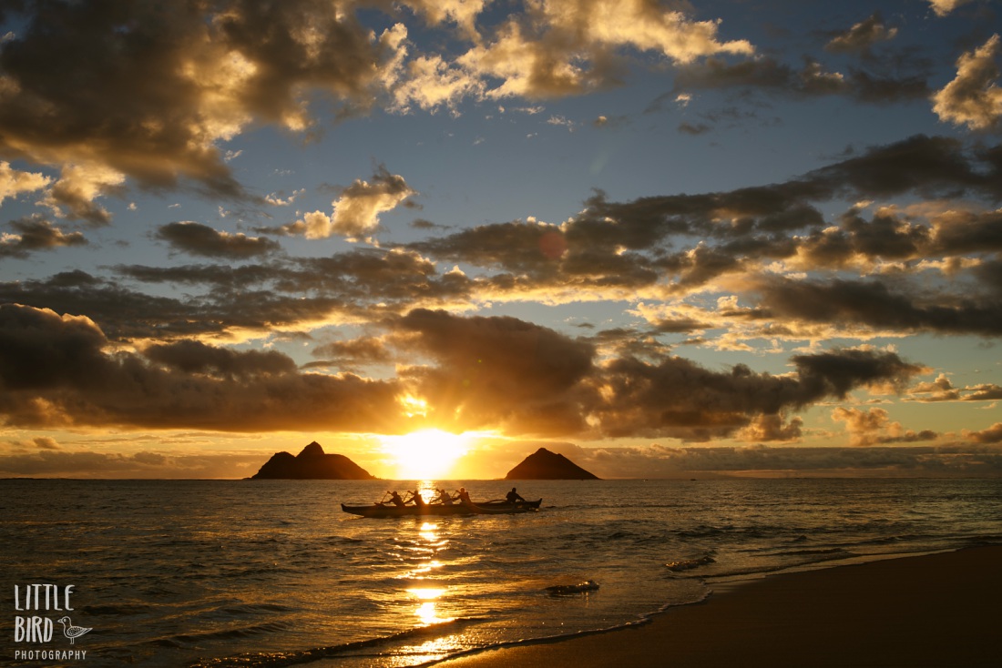 outrigger paddles past the mokula islands at sunrise on oahu hawaii