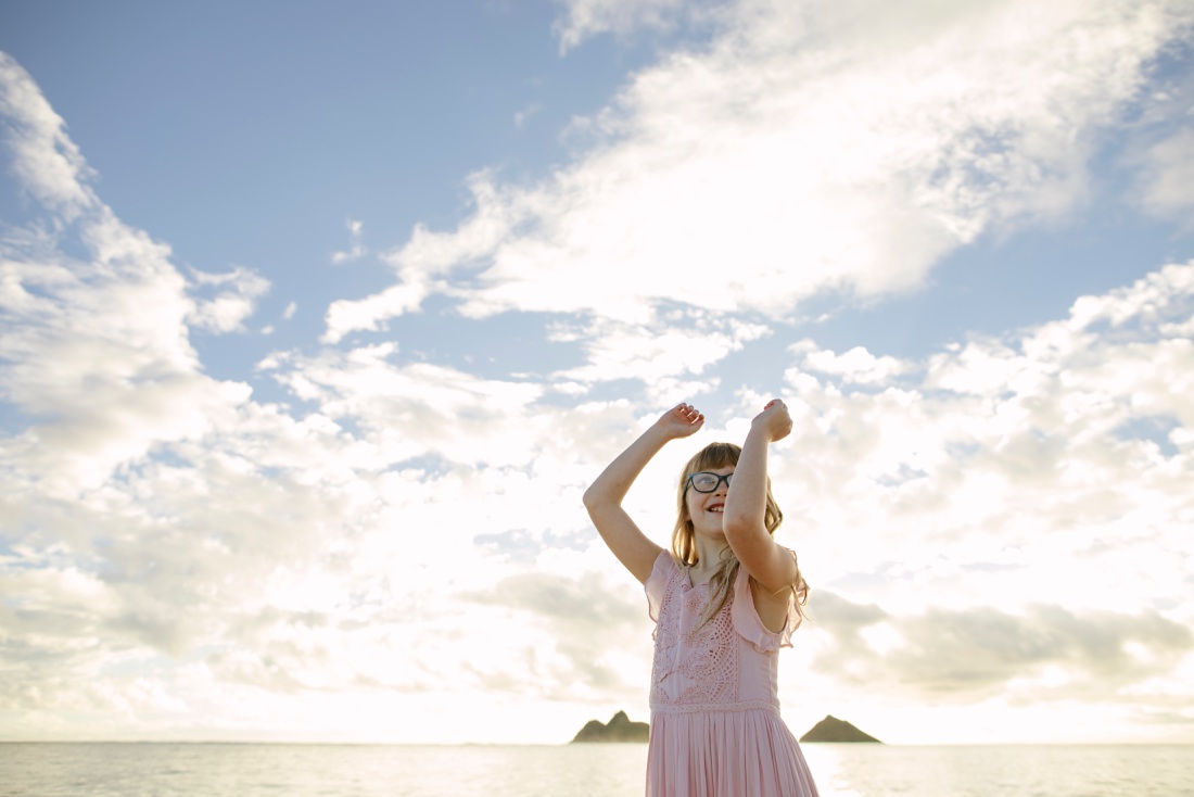 portrait of a girl dancing at lanikai beach with the mokula islands in the background