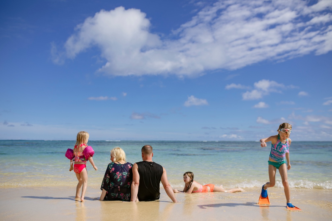family lounging on the beach in lanikai hawaii