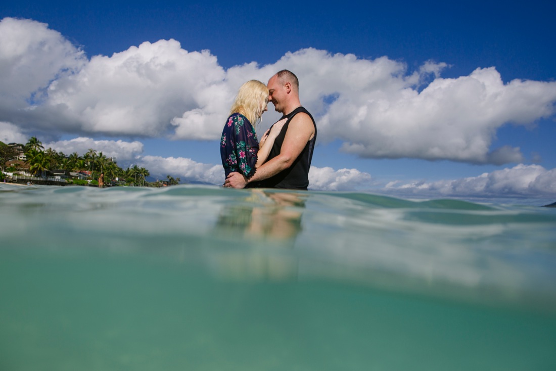 couple sharing a hug in the blue waters of lanikai beach hawaii