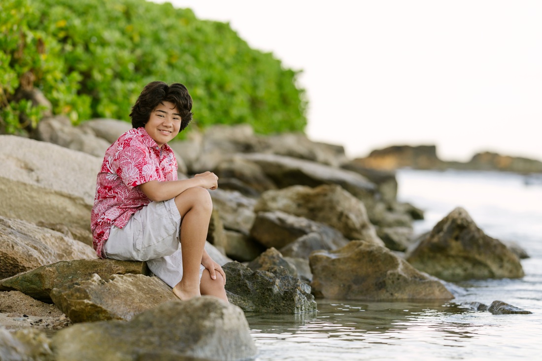 portrait of a boy sitting on rocks in paradise cove