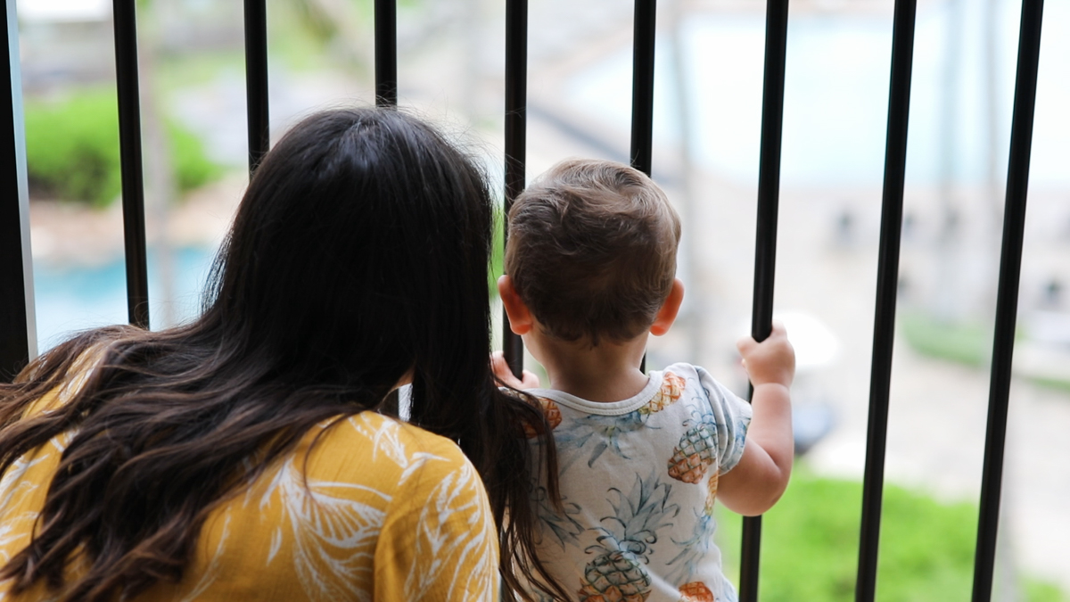 mom and toddler look out from their hotel room at turtle bay resort