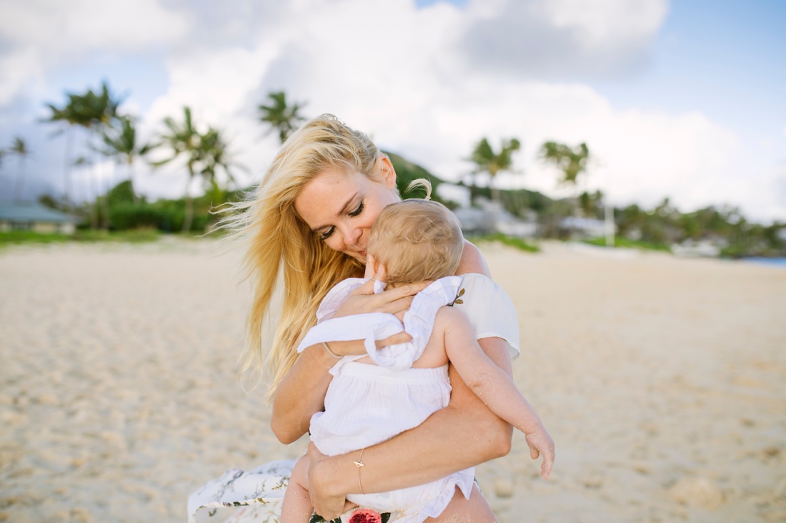 mom snuggles baby during a family photo shoot in lanikai beach oahu