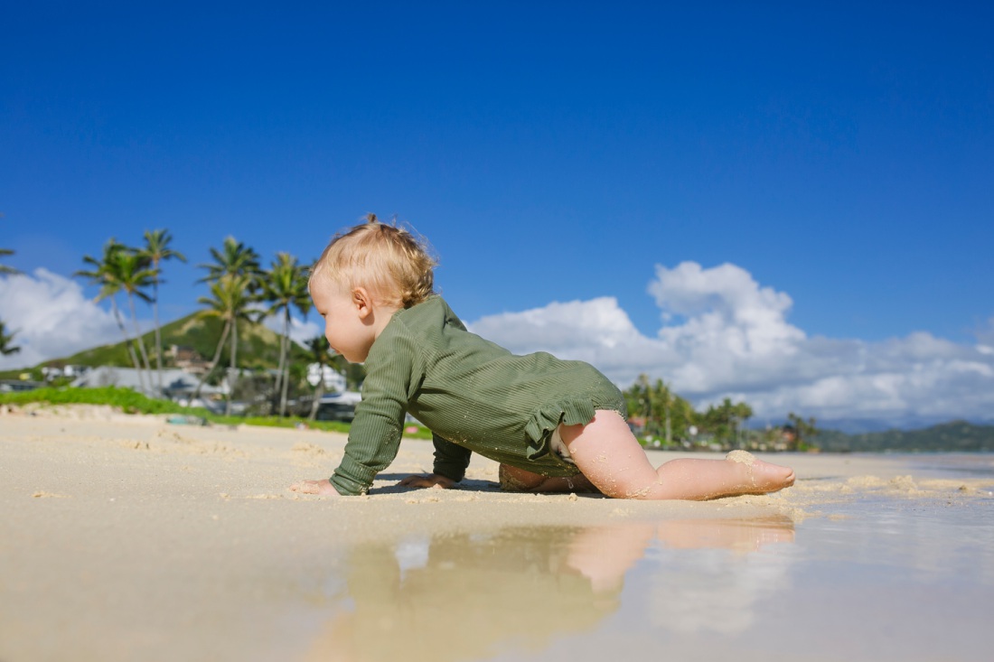 baby crawling on lanikai beach with reflections
