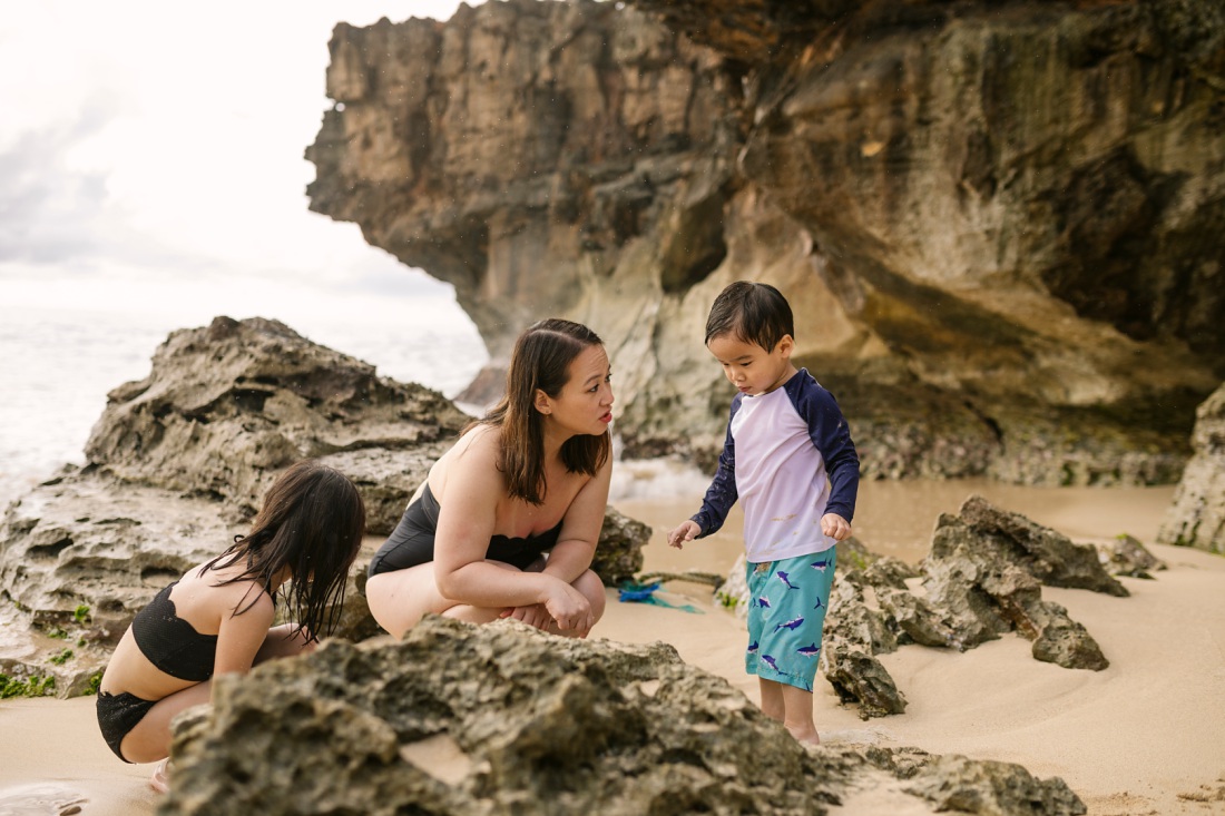 mom and kids exploring marine life next to the cliffs at laie beach park hawaii