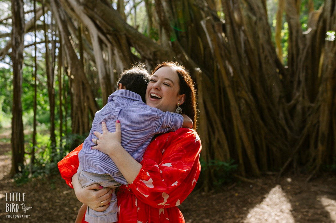 mom laughing while hugging son during a fun family photo session in hawaii