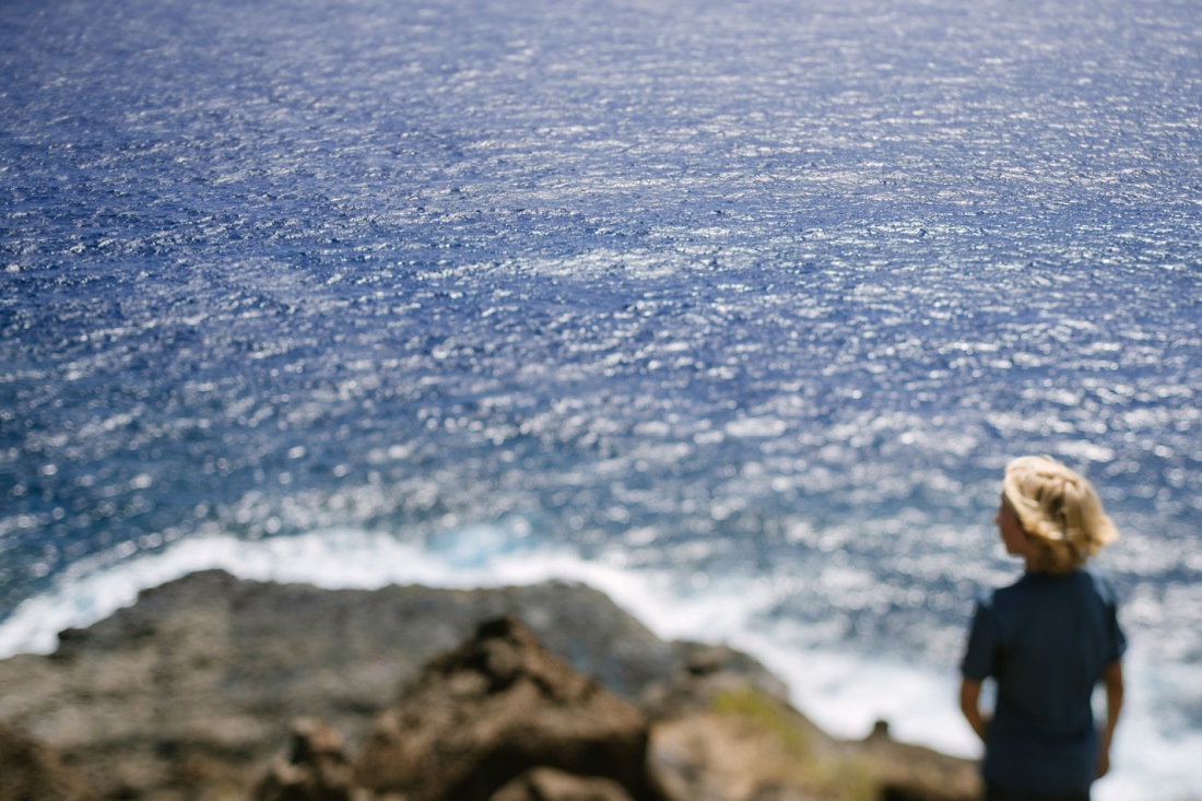 boy standing on the edge of the trail to the makapuu tide pools