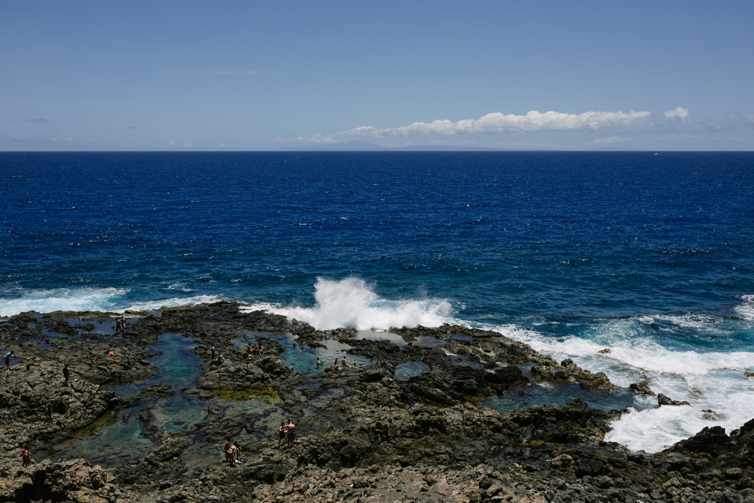 view of the makapuu tide pools from the trail with waves splashing