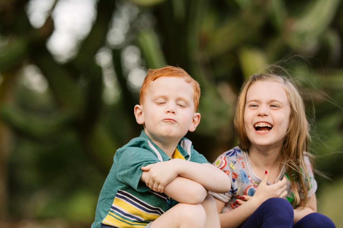 siblings sharing a laugh during a family photoshoot in oahu