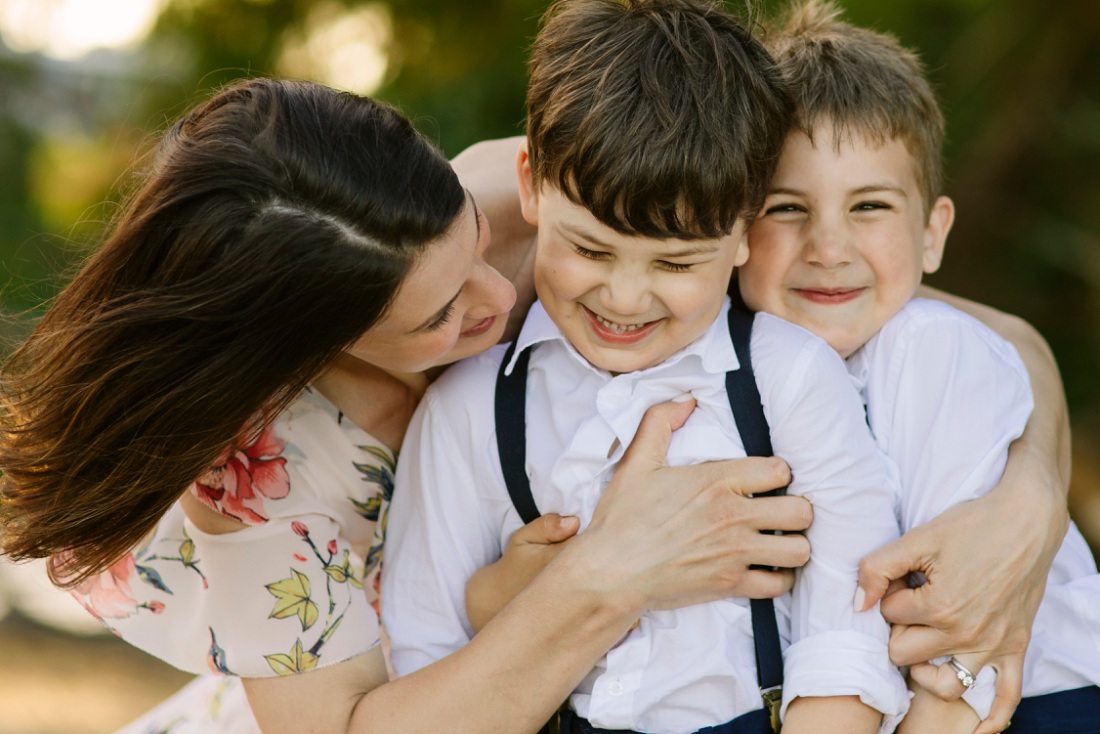 fun portrait of mom hugging her two boys during a hawaii family photo session