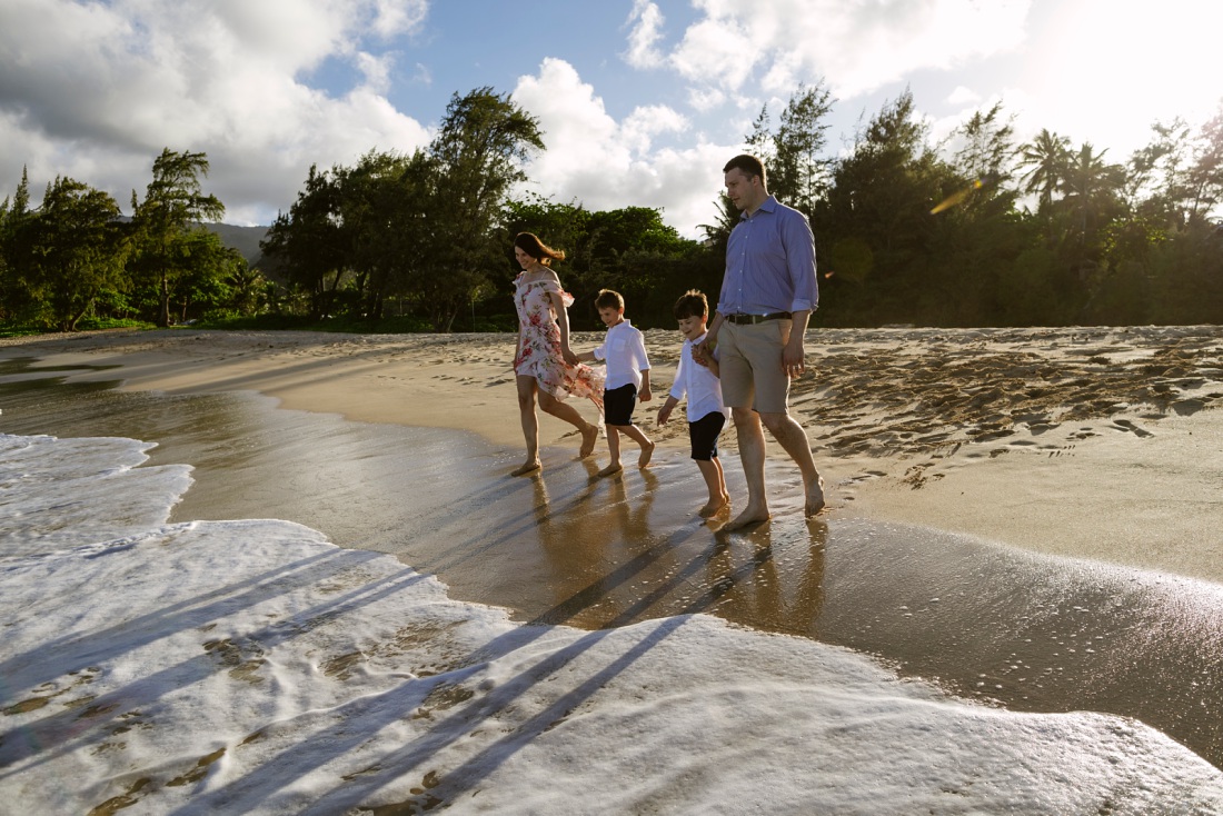 family walking toward the water at sunset in hawaii