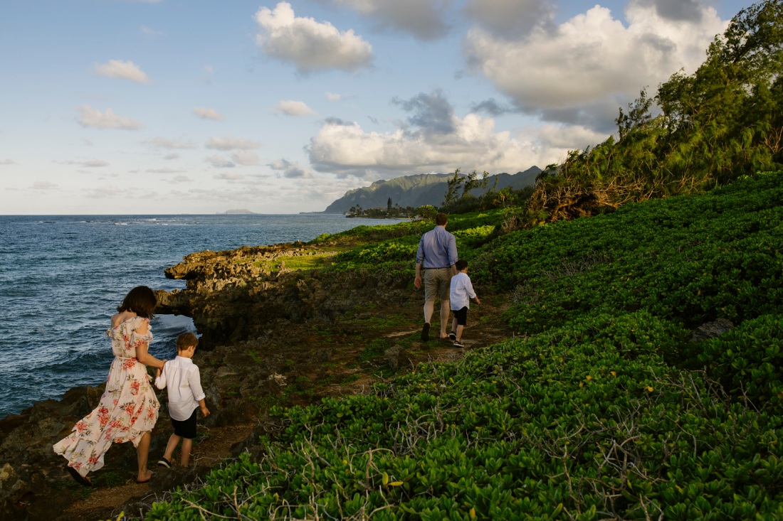 family walking along the cliffs in oahu during a family photo session by little bird photography