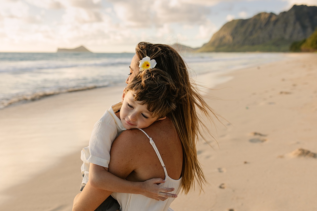 mom and son cuddle during a family photo session in hawaii